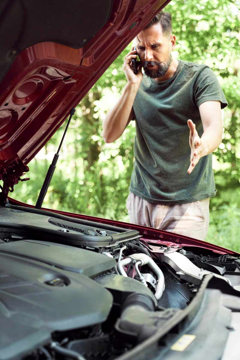 Junger Mann prüft Getriebeschaden bei Schrottauto Ankauf Remscheid